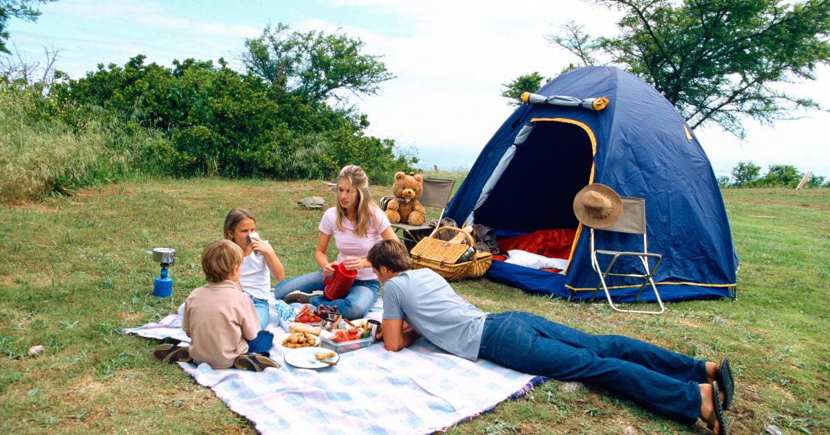 Family on a camping trip enjoying healthy foods for travel.